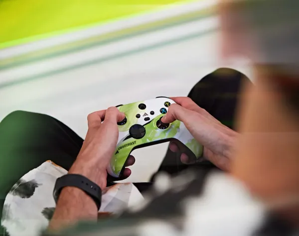 Close-up of hands using an Adidas X Crazyfast branded Xbox controller