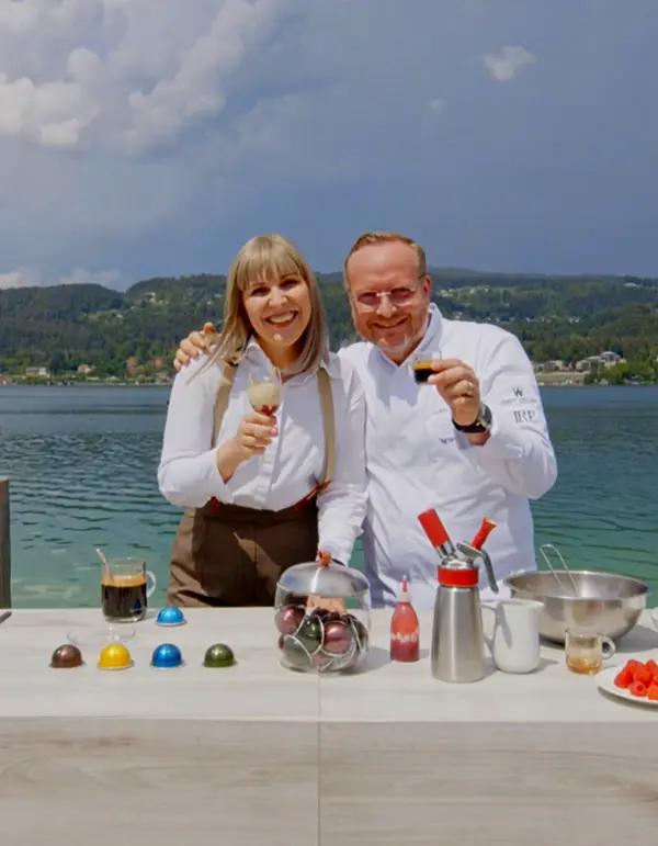 Hubert Wallner and a Nespresso representative sharing coffee beside a European lake