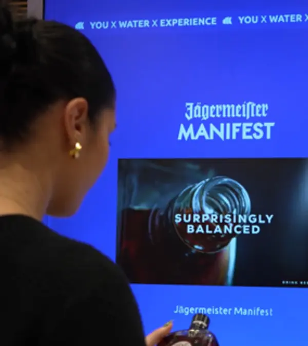 Over-the-shoulder shot of a visitor interacting with the Heinemann Copenhagen retail experience