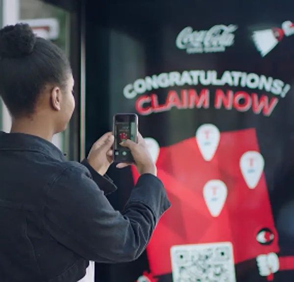Woman in London scanning a QR code on a Coke Zero digital outdoor display