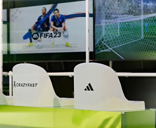 Adidas X Crazyfast esports area with branded stadium seats and FIFA gameplay on screen