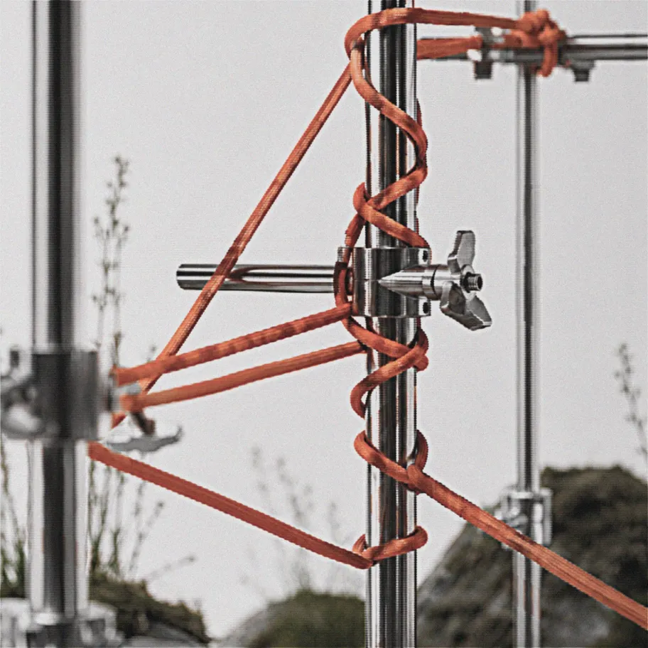 Grit shoelace wrapped around a laboratory-style frame in a white studio environment