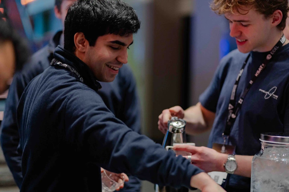 Man smiling with another man pouring coffee