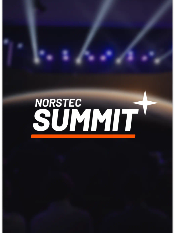Audience watching a large stage with a screen showing the NORSTEC logo over a planet backdrop, with purple and blue stage lights overhead.