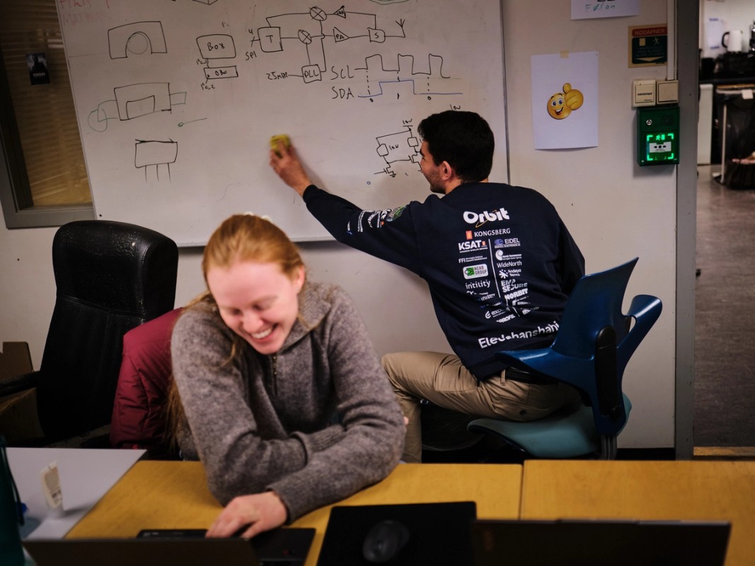 students writing on white board and laughing
