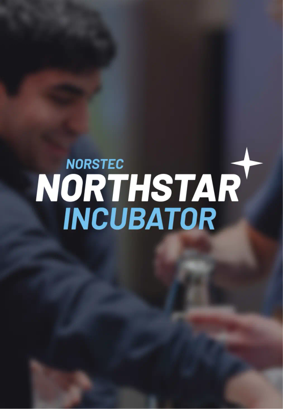 Two smiling young men working together at an event, preparing drinks at a counter.