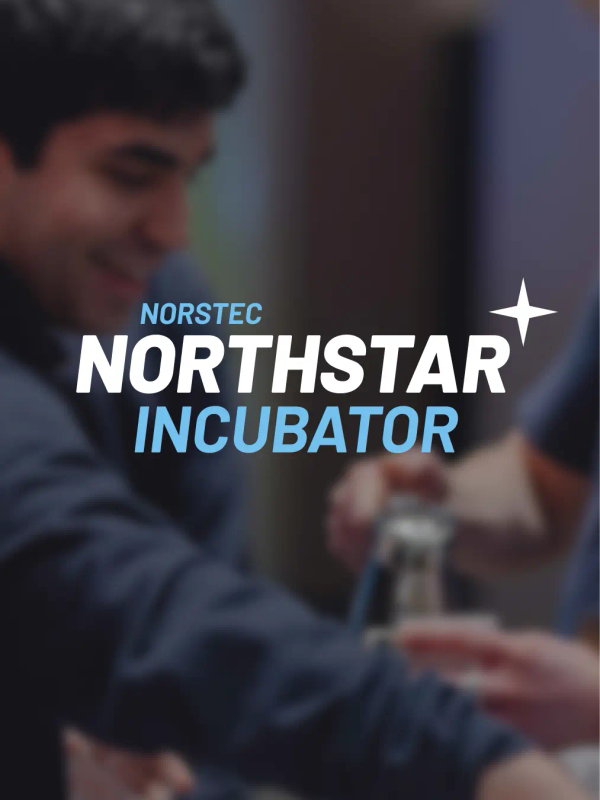 Two smiling young men working together at an event, preparing drinks at a counter.