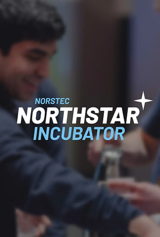 Two smiling young men working together at an event, preparing drinks at a counter.