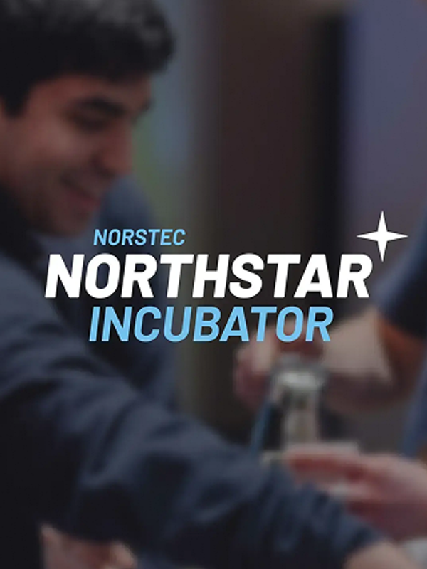 Two smiling young men working together at an event, preparing drinks at a counter.