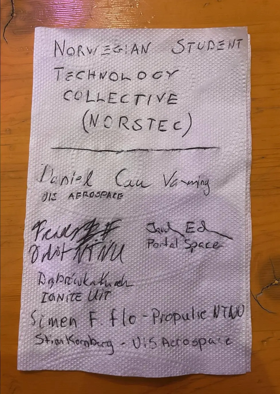 A handwritten napkin with the early concept sketch and signatures from the founders of NORSTEC, the Norwegian Student Technology Collective.
