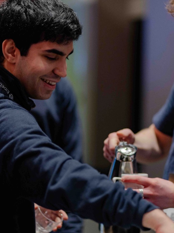Students talking and drinking coffee at stand