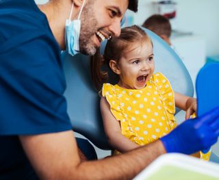 Dentist showing young patient their teeth in a mirror