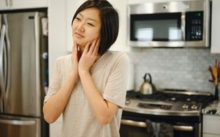 Image of a woman at her home with pain in her jaw.