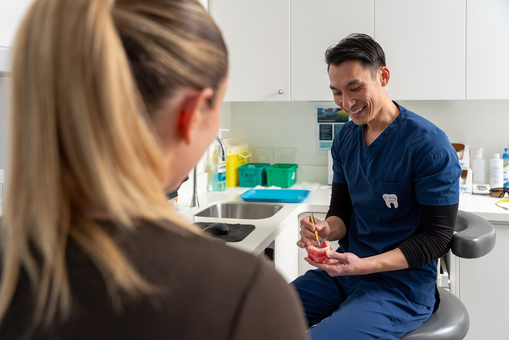 Image of Dr Chris Karikios showing a dental patient their smile preview in our clinic in CBD Sydney.