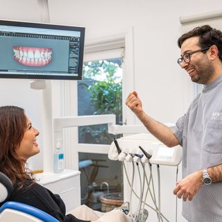 Image of Dr. Adam Sibio with his patient explaining the Invisalign® treatment.