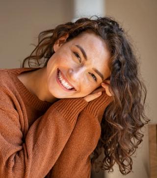 Image of a lady in the sun with a big white smile on her face.