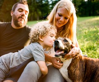 Family and dog playing happily in a park