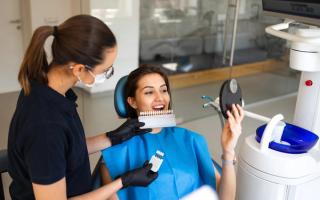 Image of a patient with a dentist going through a shade assessment for her veneer treatment.