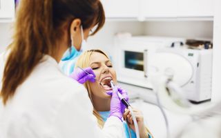Stock image of a patient being examined by a dentist.