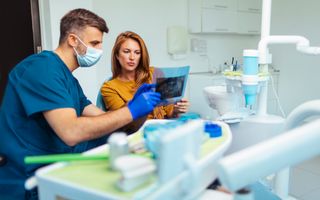Image of a dentist and female discussing their examination results.