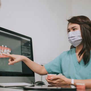 Image of a patient and dentist showing an dental implant sample.