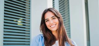Young adult woman smiling with her white teeth.