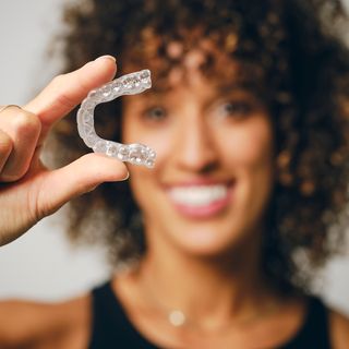 Image of a female holding a clear aligner.