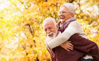 Happy senior couple playing in the park