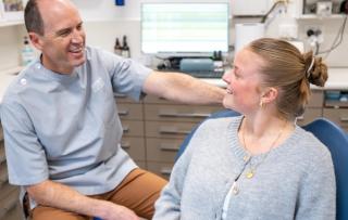 Dentist showing young patient their teeth in a mirror