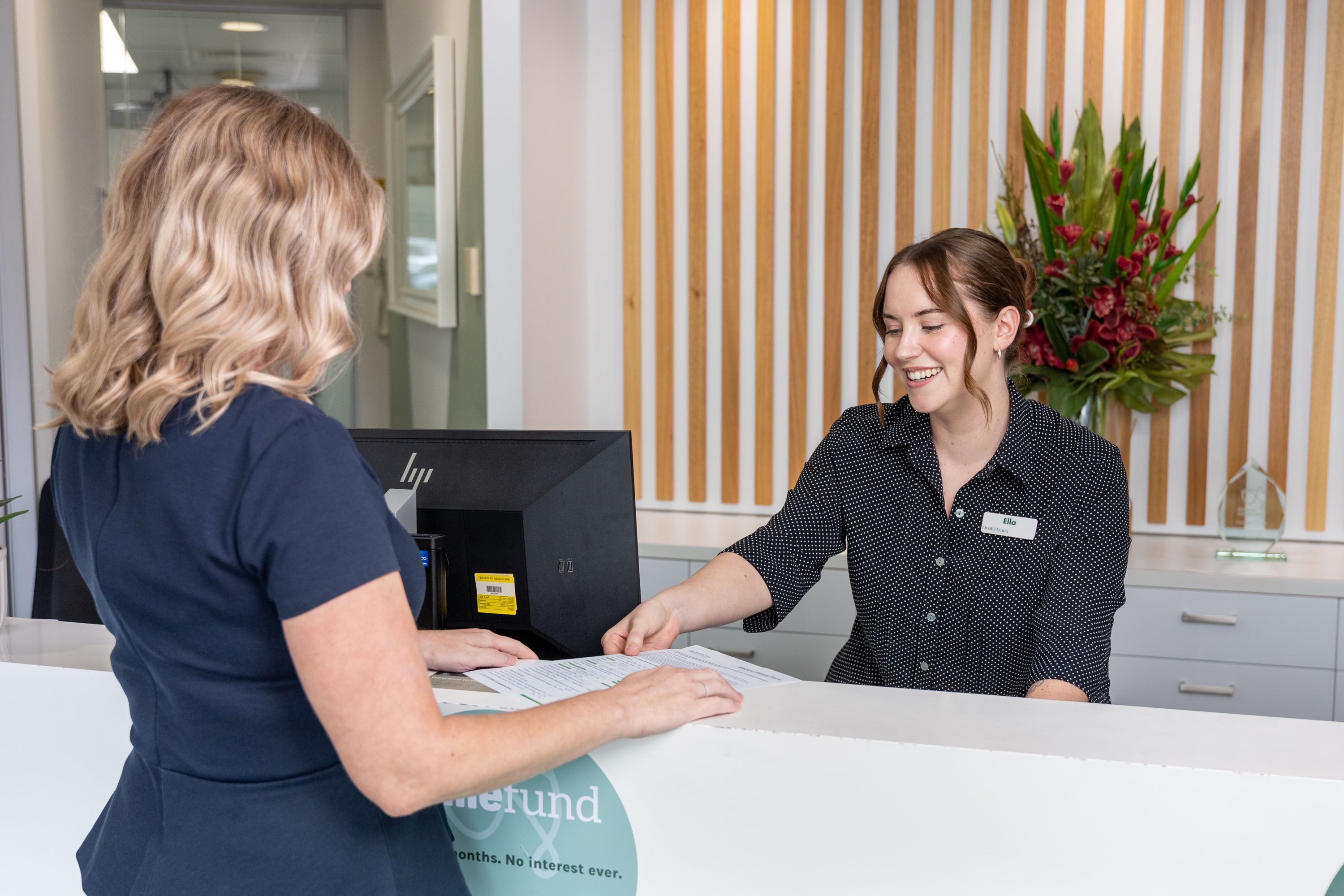 Our receptionist at DentArana, accepting documentation from one of our happy customers.