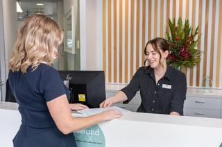 Our receptionist at DentArana, accepting documentation from one of our happy customers.