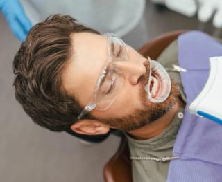 Image of a man at a dental clinic about to undergo a teeth whitening procedure.