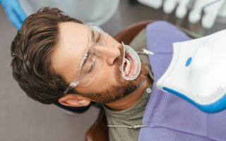 Image of a man at a dental clinic about to undergo a teeth whitening procedure.