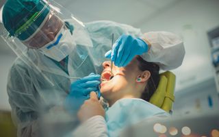 Image of a dentist checking his patient's teeth.