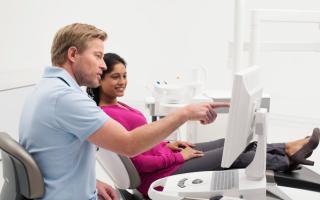 Dentist explaining digital scan results with a patient