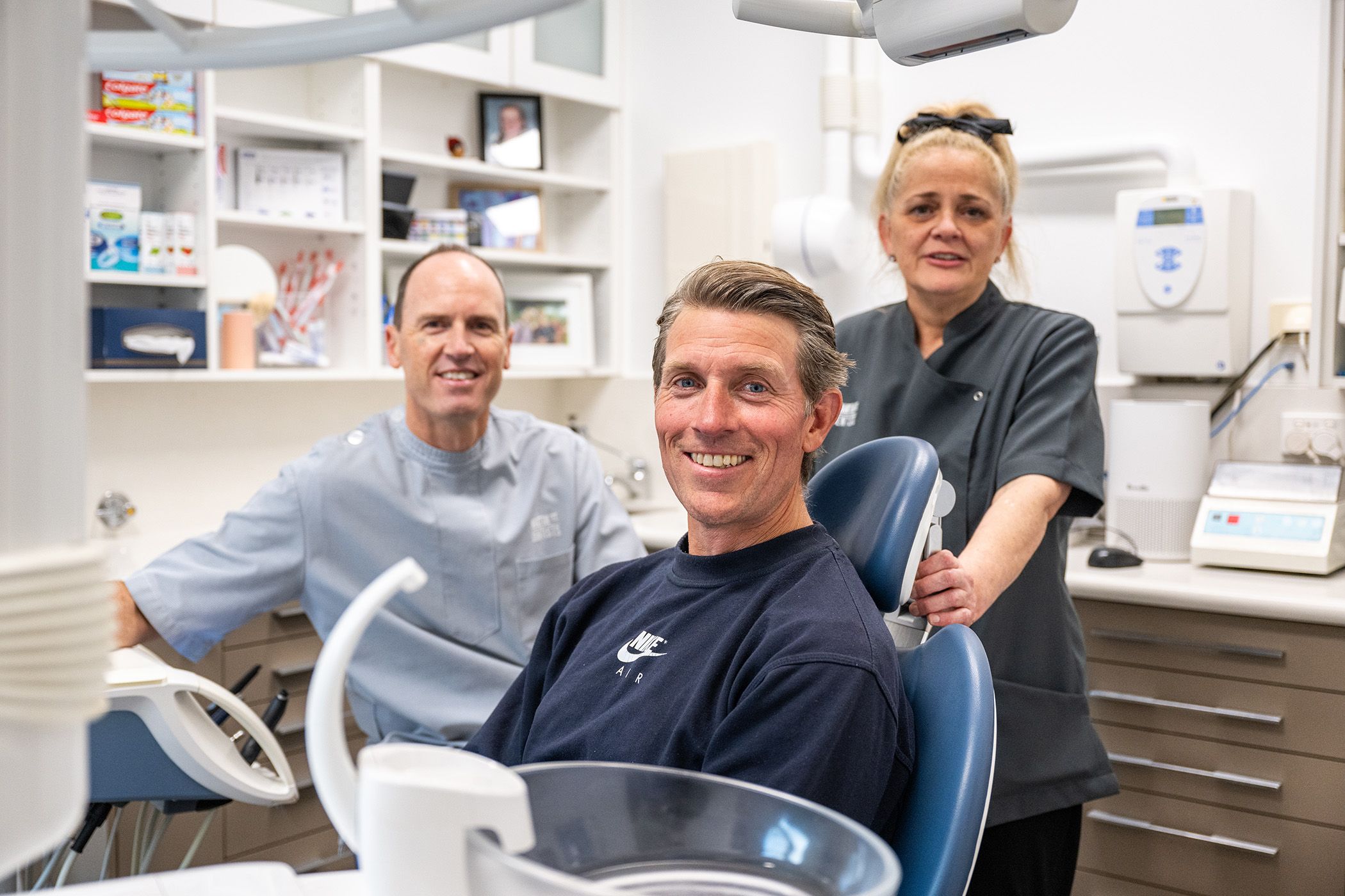 Image of Dr. Tim Nicolls with his dental assistant and his happy patient. 