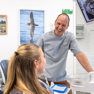 A dentist bonding with her young patient to create a comfortable and relaxing atmosphere.