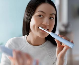 A female patient using her new sonic toothbrush
