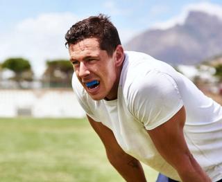 Image of a young man playing sport with his mouthguard.