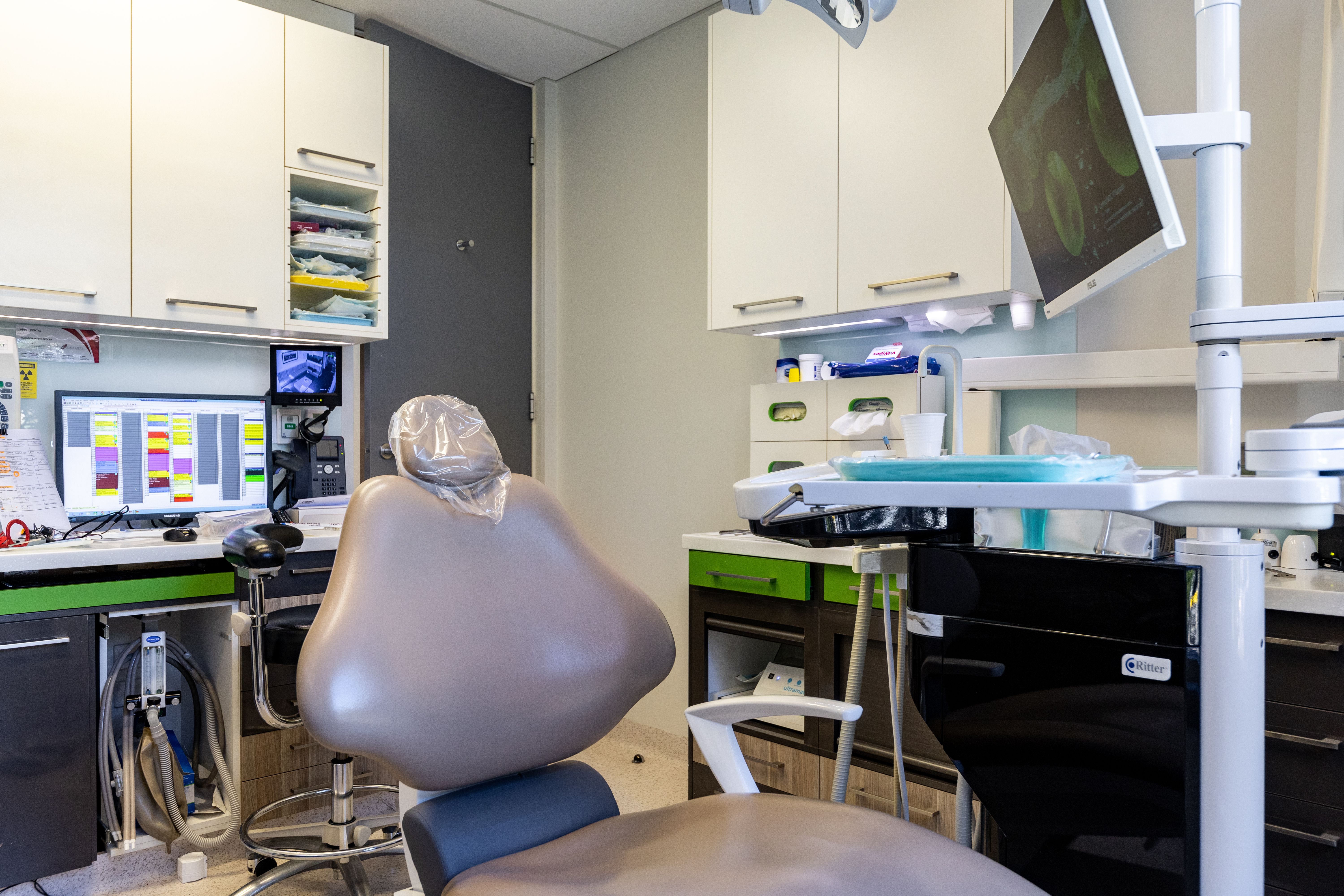 A dental chair that is surround by our modern technology.