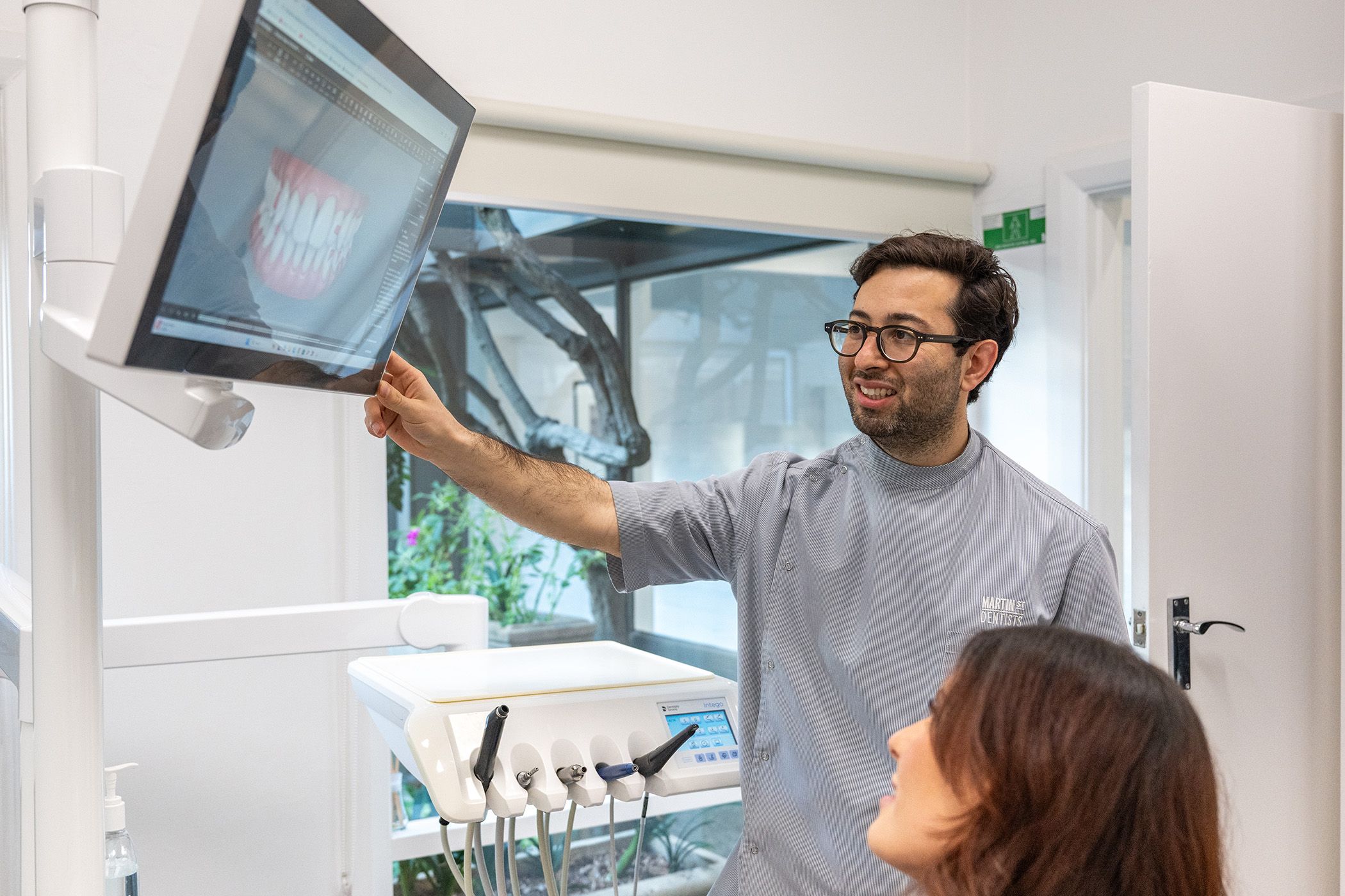 Image of Dr Adam Sibio with his patient in his dental space.