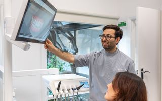 Image of Dr Adam Sibio with his patient in his dental space.
