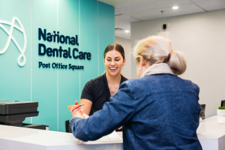 An image of our dental reception helping a patient fill in their dental history. 