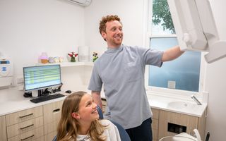 Image of Dr Brett Borger with his patient in his dental space.