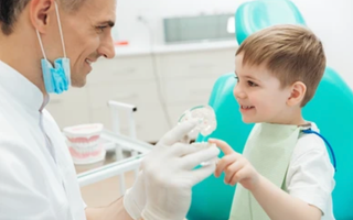 Dentist talking with child about dental treatment