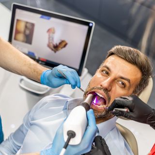 Image of a patient in a dental chair undergoing a regular check-up.