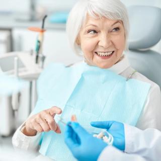 Image of a patient holding a mini implant.