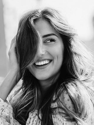 A black and white image of a smiling woman