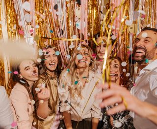 Stock image of group of people celebrating with beaming smiles on their faces.