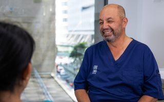 Image of our dentist, Dr Sam Guirguis smiling with his patient.